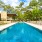 a swimming pool with trees and a building in the background