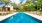 a swimming pool with trees and a building in the background